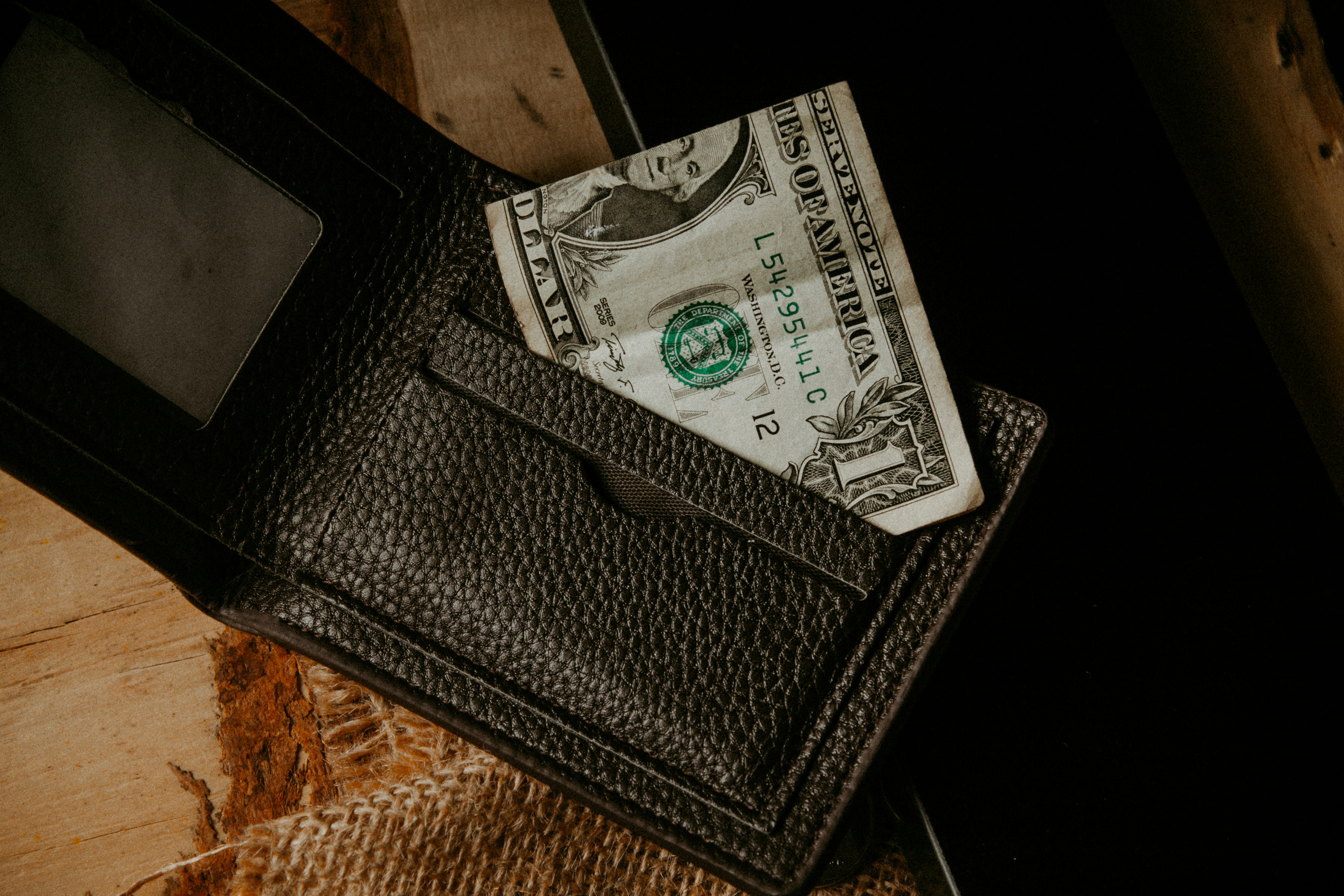 a wallet with a dollar bill sticking out of it